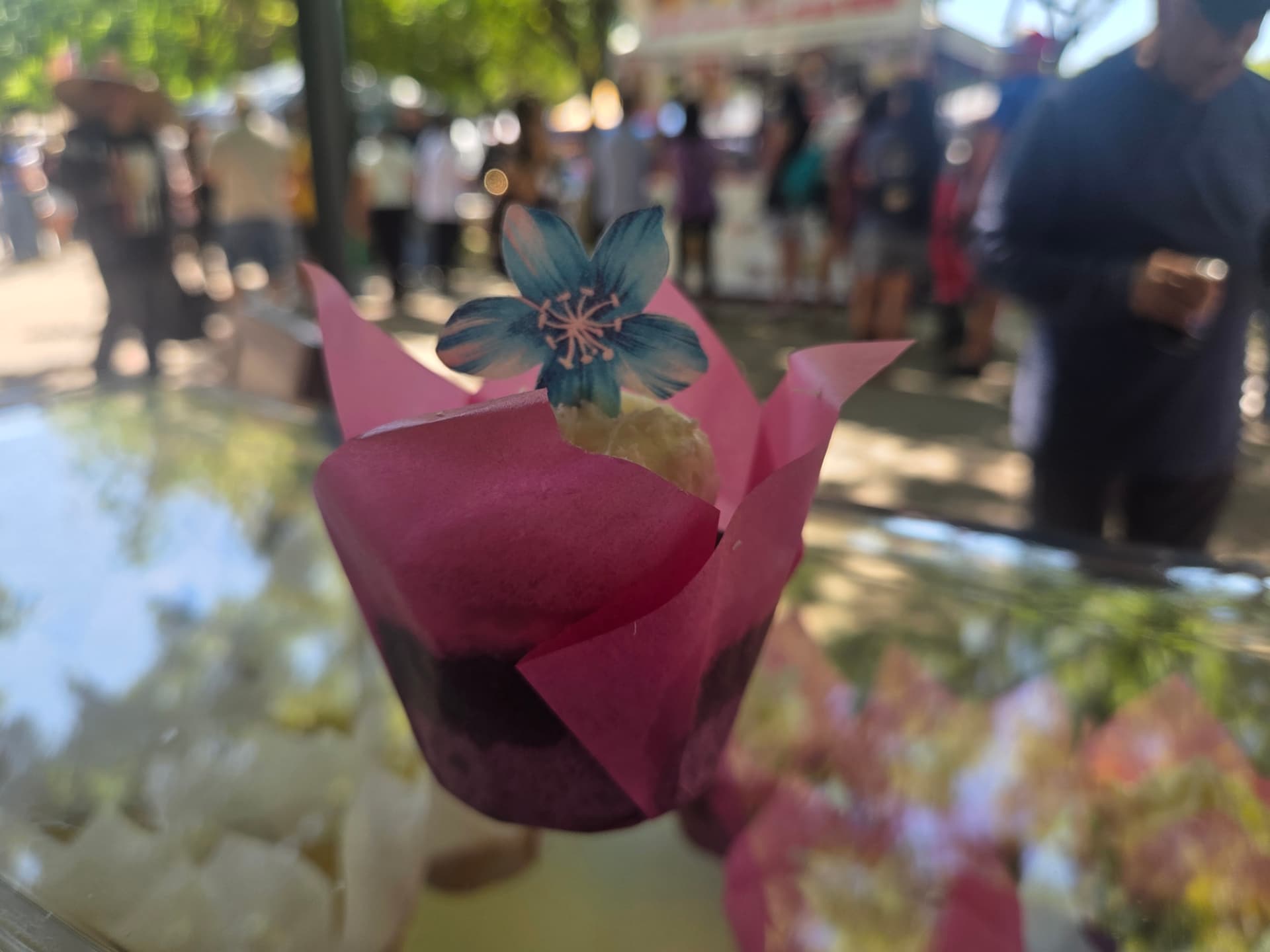 Cupcake in a pink liner topped with a blossom pick